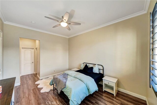 bedroom with ornamental molding, wood finished floors, and baseboards