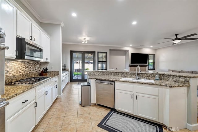 kitchen featuring a sink, backsplash, stainless steel appliances, and plenty of natural light