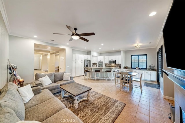 living area featuring light tile patterned flooring, recessed lighting, a ceiling fan, and ornamental molding
