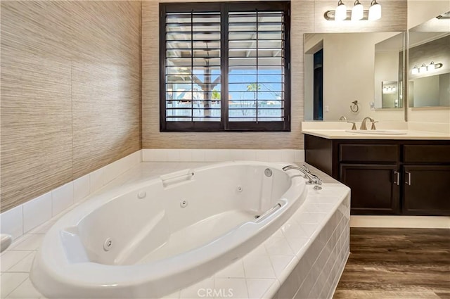full bath featuring a tub with jets, wood finished floors, and vanity