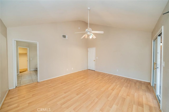 empty room with high vaulted ceiling, ceiling fan, visible vents, light wood finished floors, and baseboards