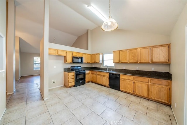 kitchen with a sink, black appliances, decorative light fixtures, and dark countertops