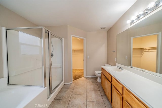 full bathroom featuring vanity, a stall shower, tile patterned flooring, toilet, and visible vents
