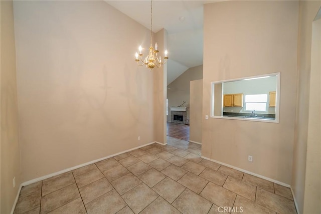 unfurnished dining area featuring a chandelier, light tile patterned floors, baseboards, and lofted ceiling