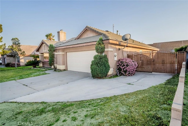 view of front of home with a tiled roof, stucco siding, an attached garage, a chimney, and driveway