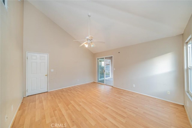 empty room featuring light wood-style flooring, high vaulted ceiling, and a ceiling fan