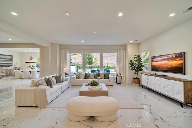 living room featuring recessed lighting, a notable chandelier, visible vents, and marble finish floor