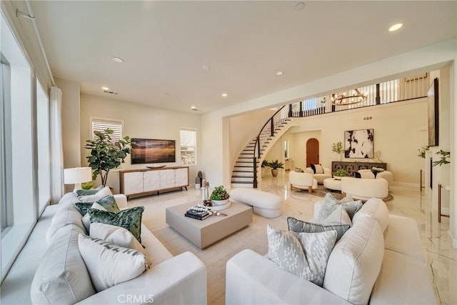 living area with recessed lighting, stairs, a notable chandelier, and marble finish floor