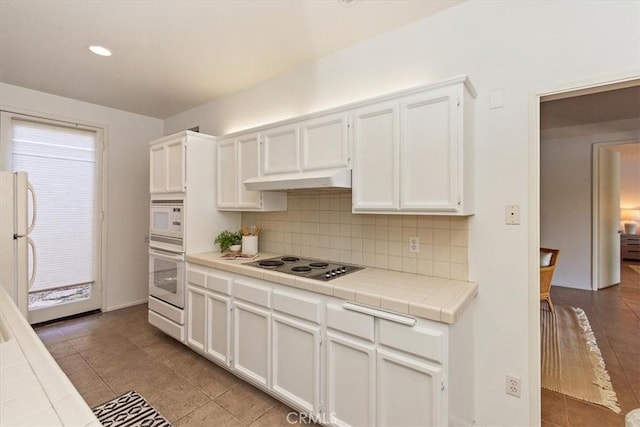 233 Lake Shore Dr, Rancho Mirage, CA 92270 - kitchen with white appliances, tile countertops, backsplash, white cabinets, and tile patterned floors