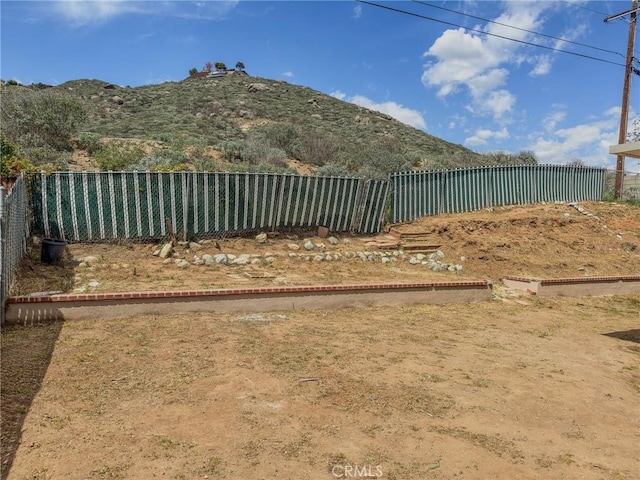 view of yard featuring a mountain view and fence