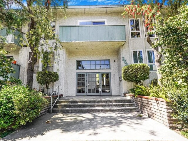 3649 Glendon Ave Unit 208, Los Angeles, CA 90034 - view of exterior entry with a balcony, french doors, and stucco siding