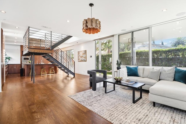 living room with visible vents, expansive windows, wood finished floors, stairway, and recessed lighting