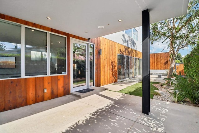 entrance to property featuring fence and a patio