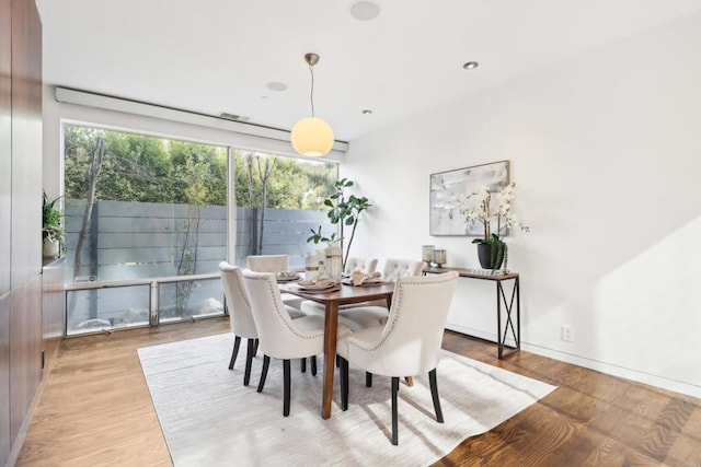 dining area featuring baseboards, visible vents, a wealth of natural light, and light wood finished floors