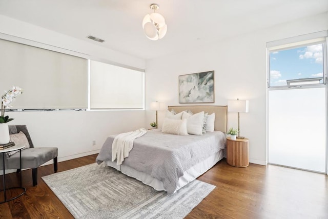 bedroom featuring visible vents and wood finished floors
