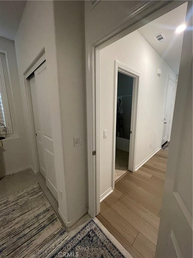 hall with wood finished floors and baseboards