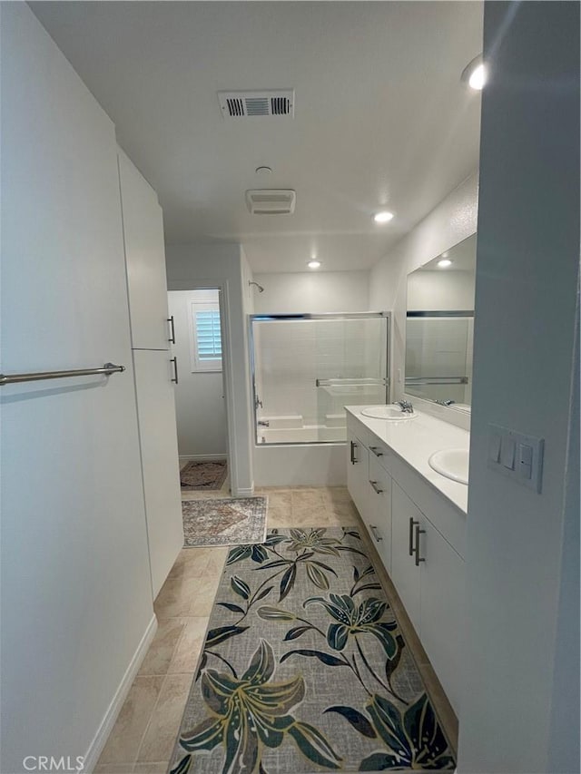 full bathroom with double vanity, recessed lighting, tile patterned flooring, shower / bath combination with glass door, and baseboards