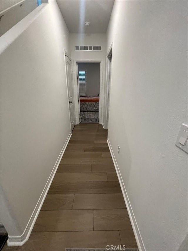 hall with dark wood-style floors and baseboards