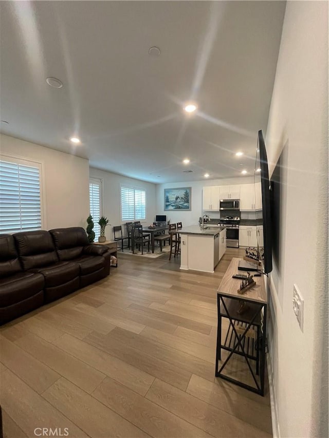 living area with light wood-style floors and recessed lighting