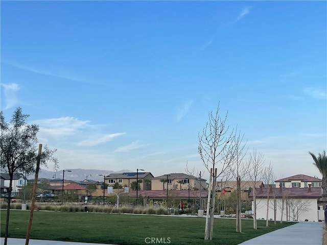view of property's community with a residential view and a yard
