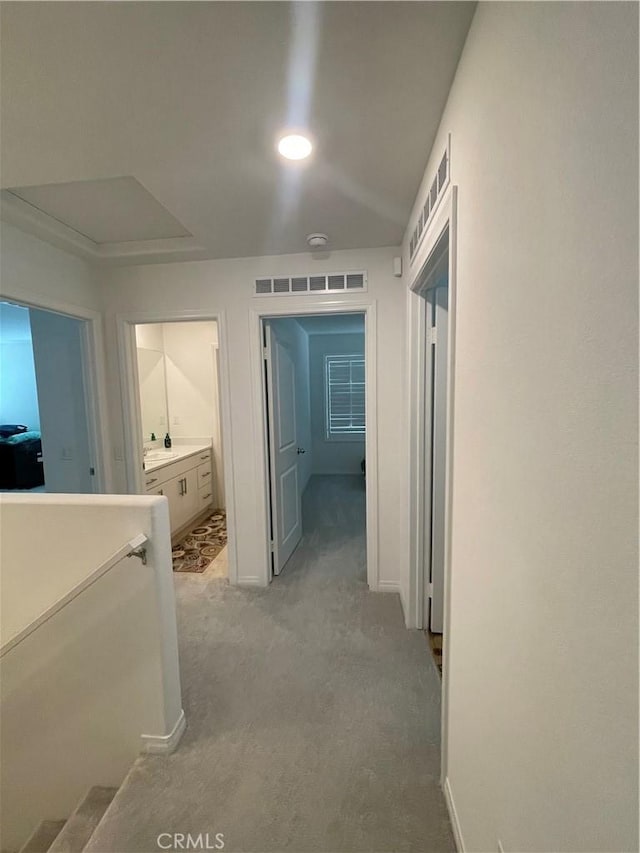 corridor with light colored carpet and baseboards