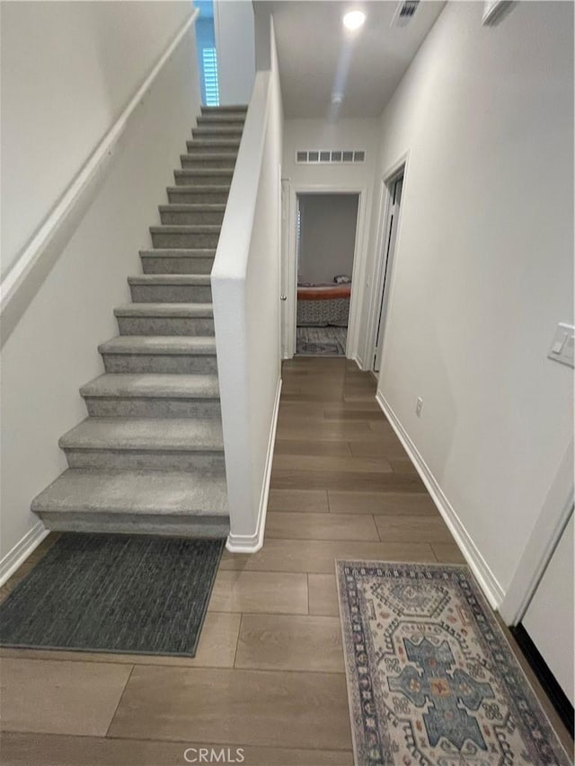 staircase with wood finished floors and baseboards