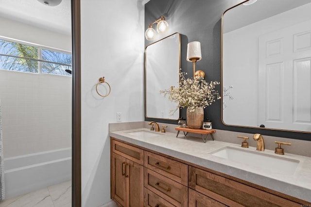 full bath featuring shower / bathing tub combination, marble finish floor, a sink, and double vanity