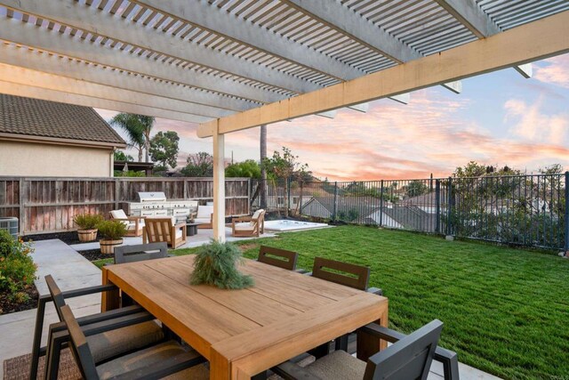 patio terrace at dusk with a yard, outdoor dining area, a fenced backyard, an outdoor kitchen, and a pergola