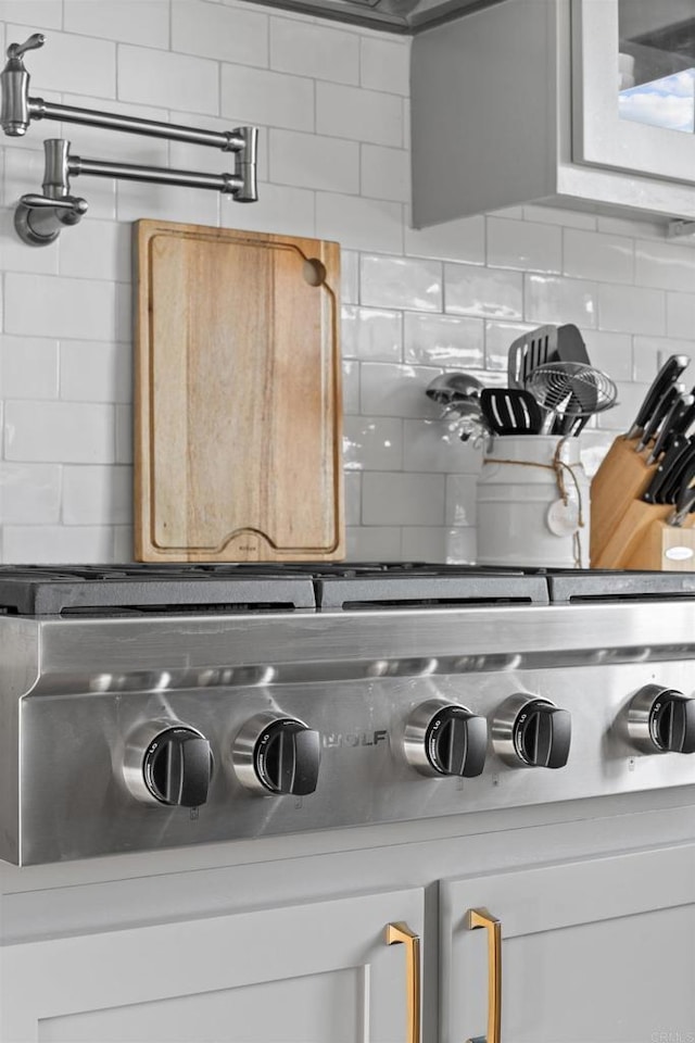 details featuring stainless steel gas stovetop and tasteful backsplash