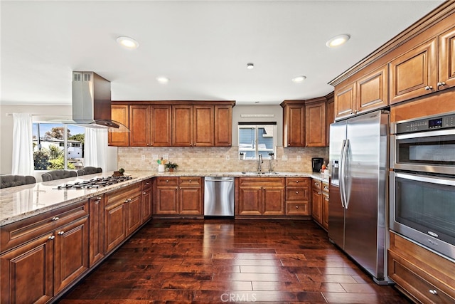 34501 Calle Carmelita, Dana Point, CA 92624 - kitchen with island exhaust hood, stainless steel appliances, a sink, light stone counters, and brown cabinetry