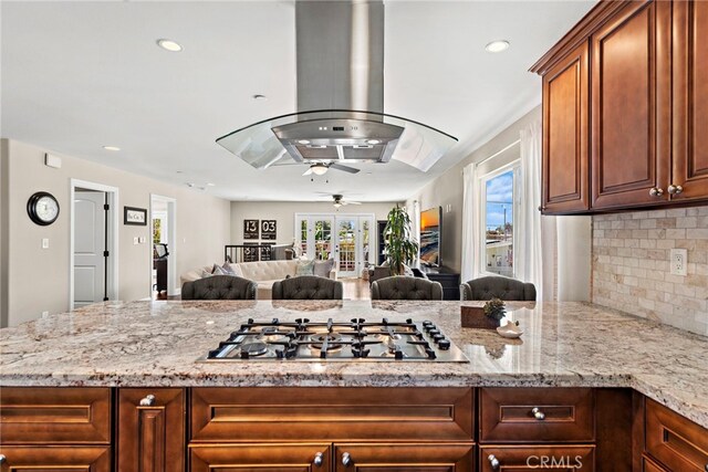 34501 Calle Carmelita, Dana Point, CA 92624 - kitchen with tasteful backsplash, stainless steel gas cooktop, island exhaust hood, ceiling fan, and light stone countertops