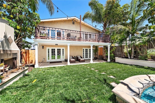 34501 Calle Carmelita, Dana Point, CA 92624 - back of house with a fenced backyard, a lit fireplace, stucco siding, and french doors
