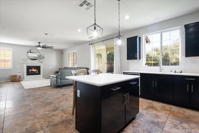 46525 Peach Tree St, Temecula, CA 92592 - kitchen with dark cabinetry, light countertops, a center island, a ceiling fan, and recessed lighting