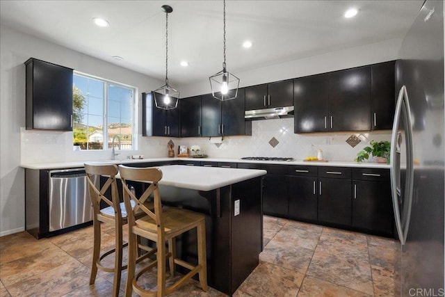 46525 Peach Tree St, Temecula, CA 92592 - kitchen with appliances with stainless steel finishes, dark cabinets, under cabinet range hood, backsplash, and recessed lighting