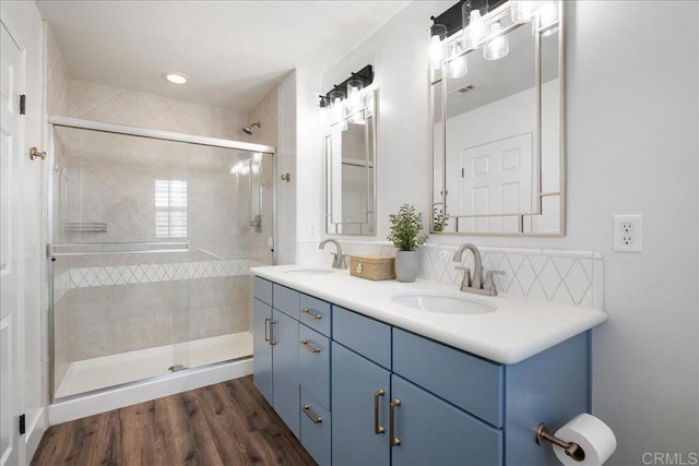46525 Peach Tree St, Temecula, CA 92592 - bathroom with double vanity, a stall shower, wood finished floors, and decorative backsplash