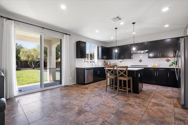 46525 Peach Tree St, Temecula, CA 92592 - kitchen featuring stainless steel appliances, dark cabinets, plenty of natural light, a center island, and recessed lighting