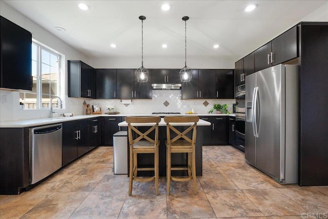 46525 Peach Tree St, Temecula, CA 92592 - kitchen featuring stainless steel appliances, a center island, backsplash, light countertops, and pendant lighting