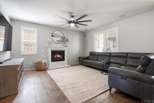 46525 Peach Tree St, Temecula, CA 92592 - living area featuring ceiling fan, a warm lit fireplace, and dark tile patterned flooring