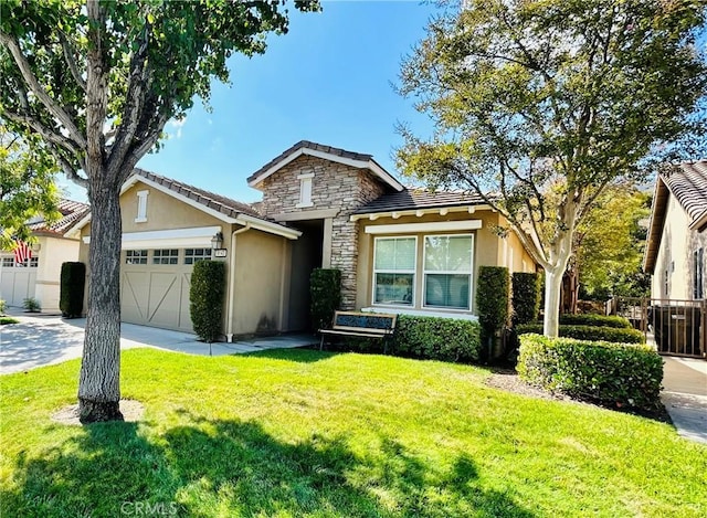 view of front of house featuring stone siding, a tiled roof, concrete driveway, a front yard, and stucco siding