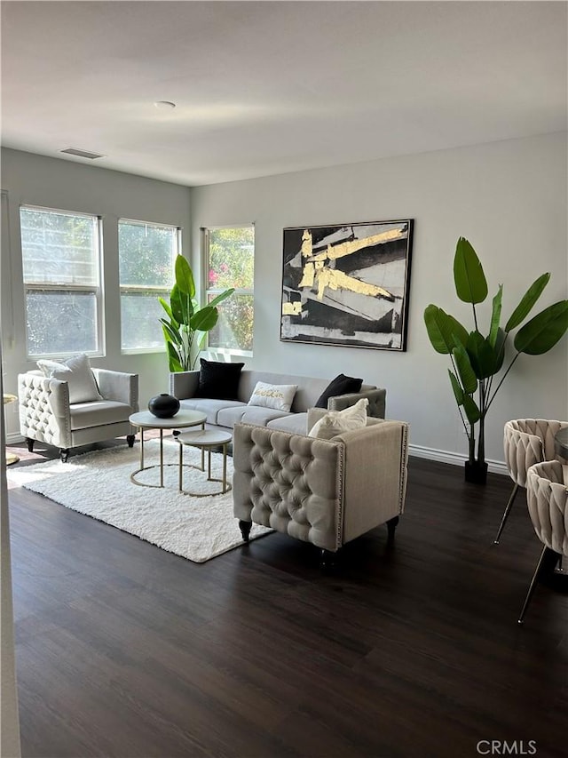 living area featuring dark wood-type flooring, baseboards, and visible vents