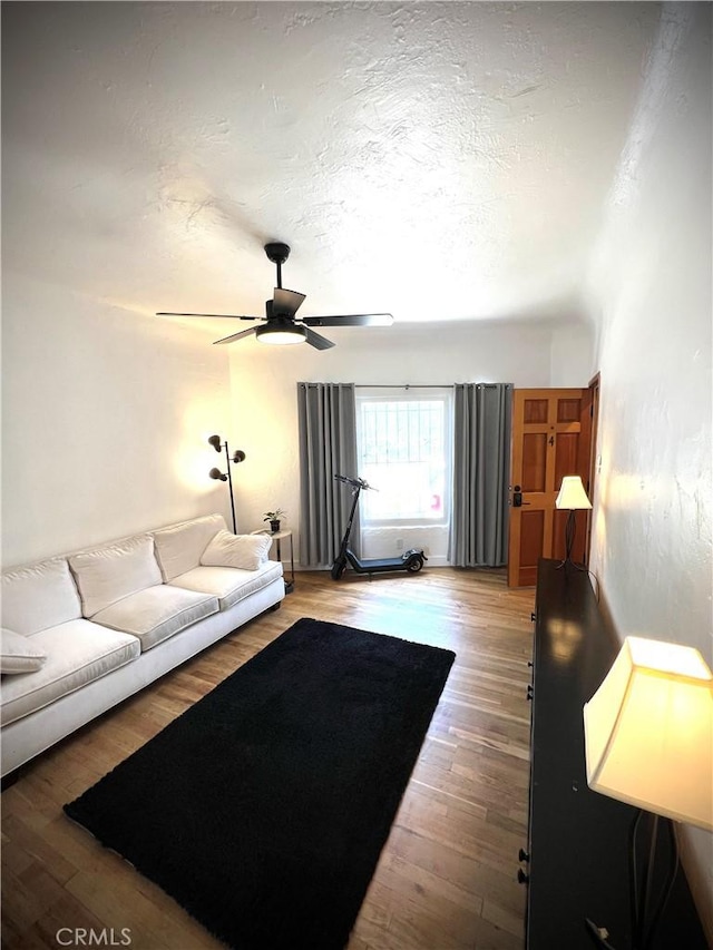 unfurnished living room featuring light wood-style flooring, ceiling fan, and a textured ceiling