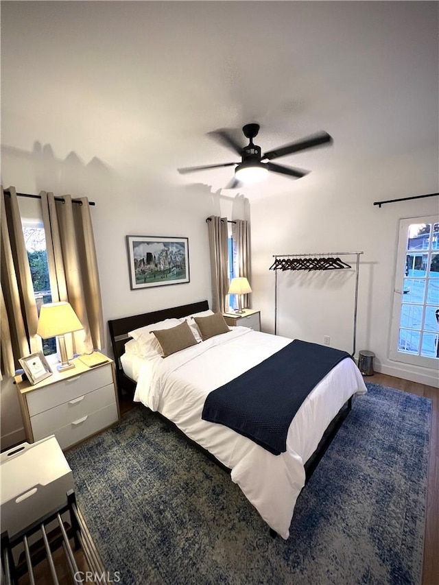 bedroom featuring multiple windows, wood finished floors, and a ceiling fan