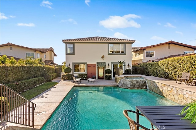 back of house with a patio area, a fenced backyard, a fenced in pool, an in ground hot tub, and stucco siding