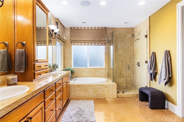 bathroom with a shower stall, a garden tub, a sink, double vanity, and recessed lighting