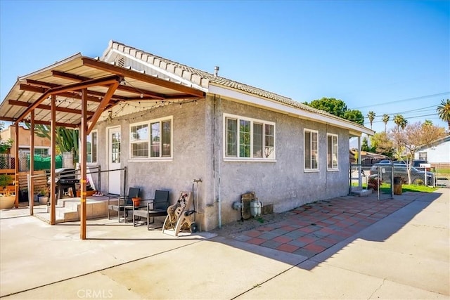 201 E Olive St, San Bernardino, CA 92410 - rear view of property with stucco siding, fence, and a patio area