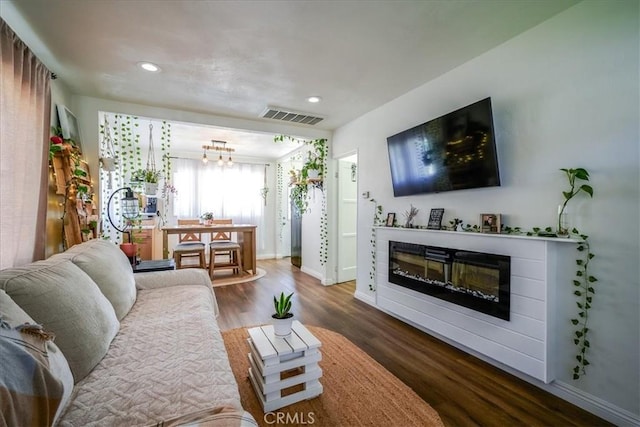 201 E Olive St, San Bernardino, CA 92410 - living room with a glass covered fireplace, visible vents, a chandelier, baseboards, and wood finished floors