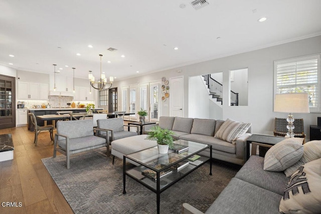4111 Adriatic St, Oxnard, CA 93035 - living room featuring recessed lighting, ornamental molding, light wood-style flooring, a chandelier, and stairway
