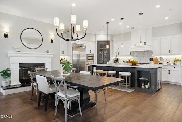 4111 Adriatic St, Oxnard, CA 93035 - dining area featuring crown molding, recessed lighting, a glass covered fireplace, a chandelier, and dark wood finished floors