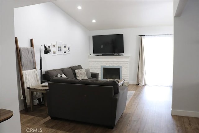 living room featuring baseboards, recessed lighting, wood finished floors, and a fireplace