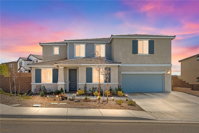 traditional-style home with concrete driveway, stucco siding, fence, and a garage